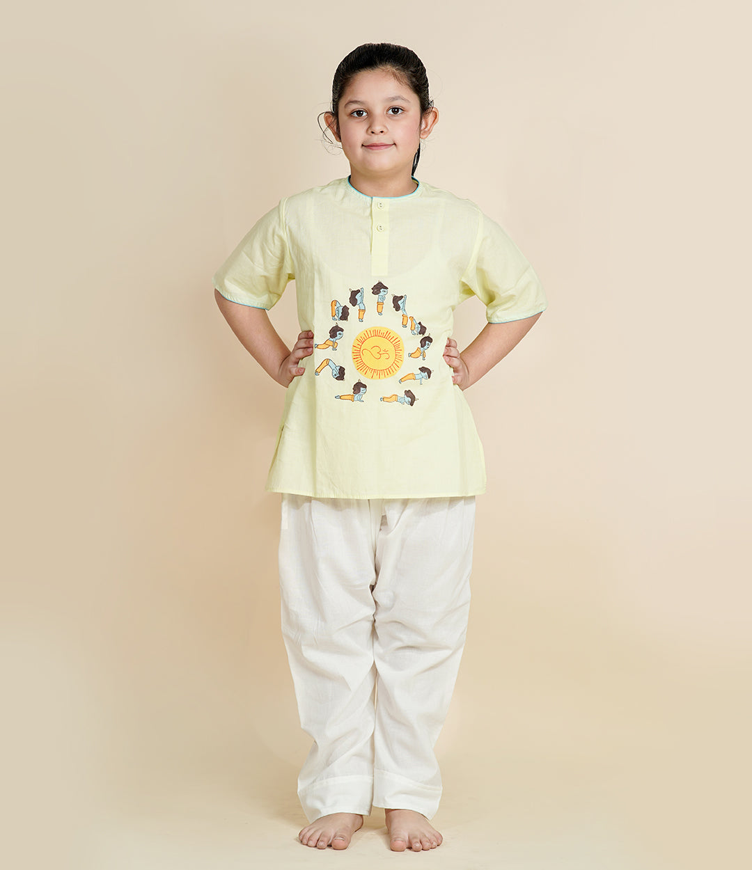 Child wearing Chanda Mama pista
green Krishna yoga outfit with
Surya Namaskar print and white
cotton pants