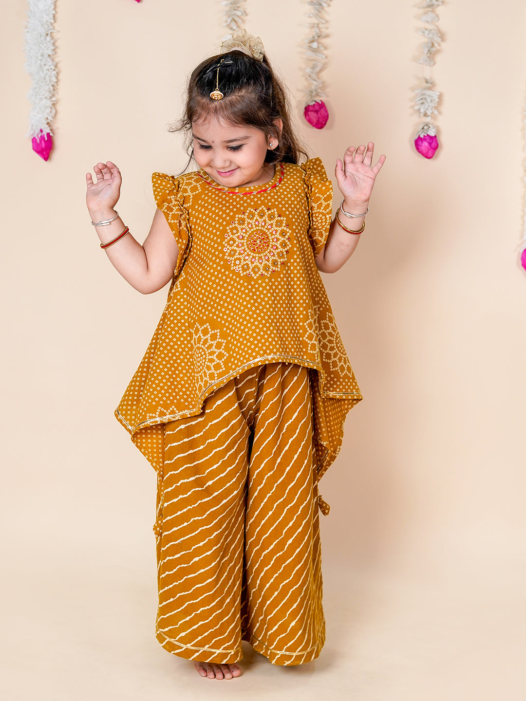 Child wearing a mustard yellow traditional outfit with a floral design on a beige background