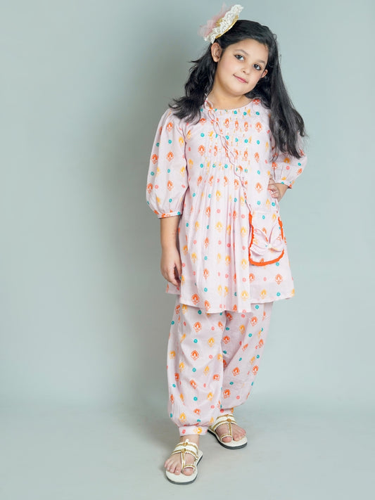 Young girl wearing a floral outfit on a plain background
