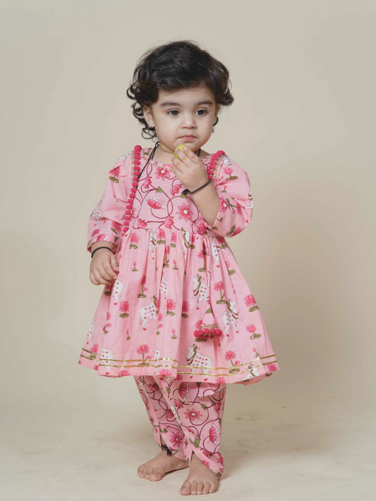 Child wearing a pink floral outfit on a beige background