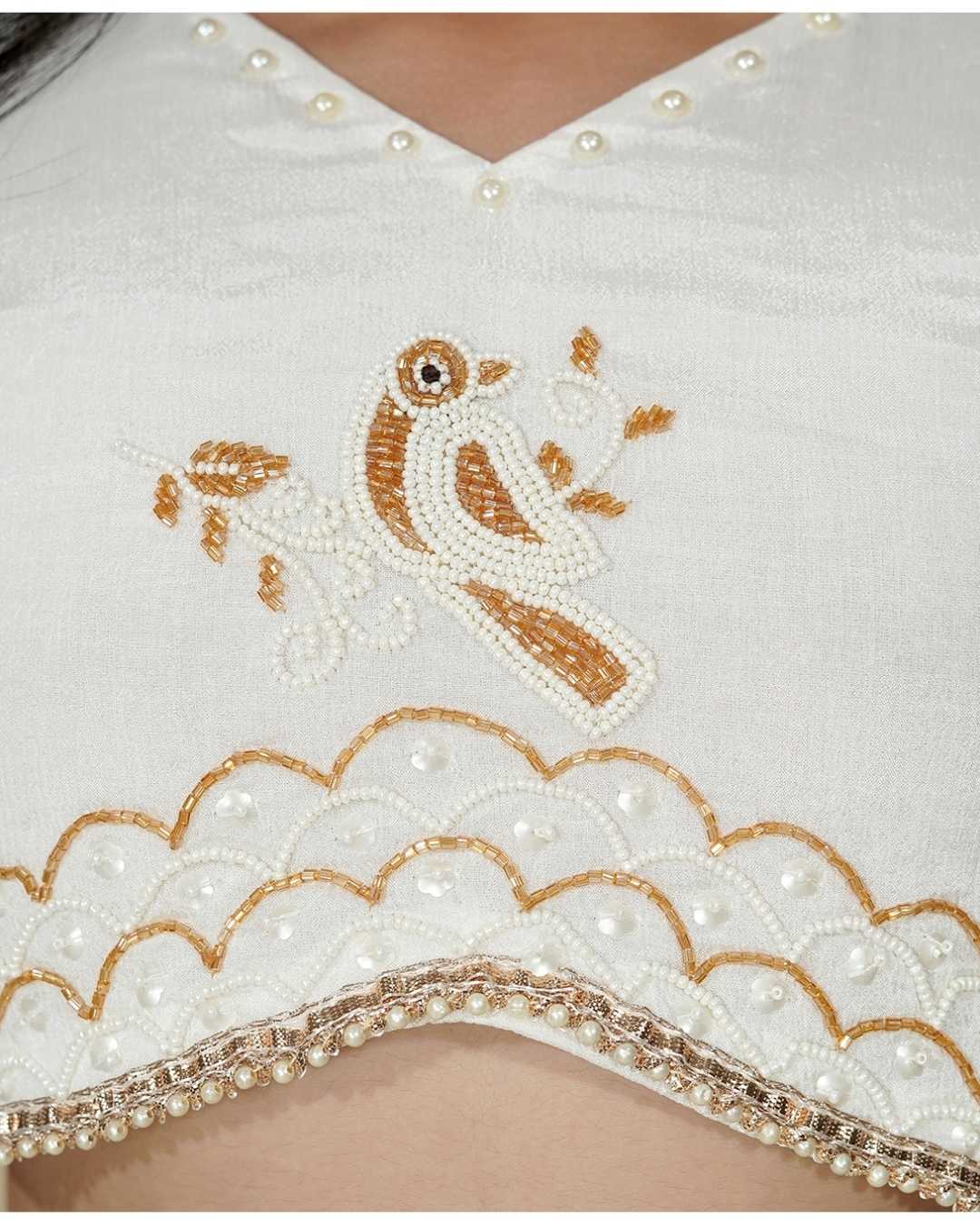 A white Top with gold embroidery and pearl details